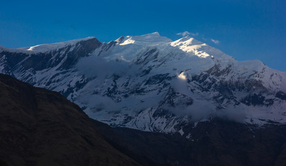 The snow capped mountain peak of Mount Tukuche on the Annapurna Circuit in Nepal.