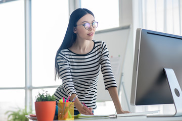 Dark-haired woman in a striped shirt looking involved
