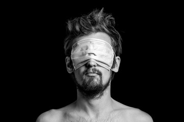 portrait of a guy on a black background, a mask on his eyes