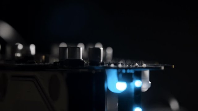 Macro View of Electronic Circuit, Microchips, 
Transistor and Capacitor on Computer Mother Board with Blinking Blue Lights. 4k