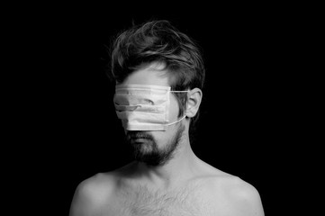 portrait of a guy on a black background, a mask on his eyes