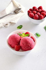 Raspberry ice cream scoop with fresh raspberries