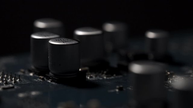 Macro View of Electronic Circuit, Microchips, 
Transistor and Capacitor on Computer Mother Board with Lights and Shadows Moving. 4k