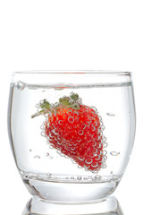 Strawberries with bubbles in a glass on a white background