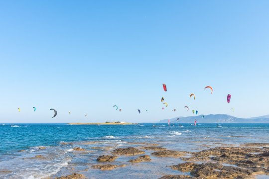Kitesurfers with colorful kites having fun in Loutsa Greece on a sunny summer day, horizontal
