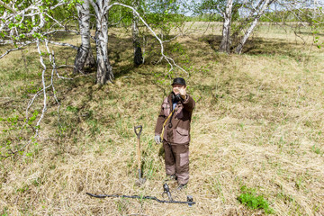 a man with a metal detector on an ancient settlement photographed from a drone