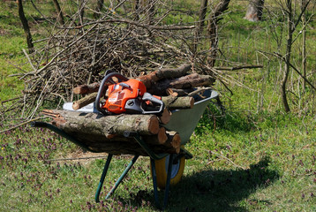 chainsaw on a wheelbarrow with firewood