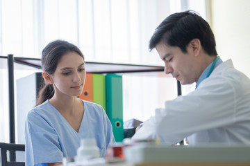 Fototapeta premium Lekarz zajmuje się chorą pacjentką w szpitalu lub przychodni.