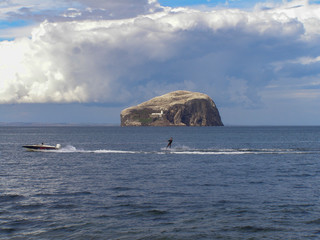 Bass Rock covered in white, Gannet seabirds at the mouth of the Firth of Forth in Scotland.