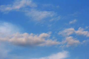 Small white clouds on dark blue background