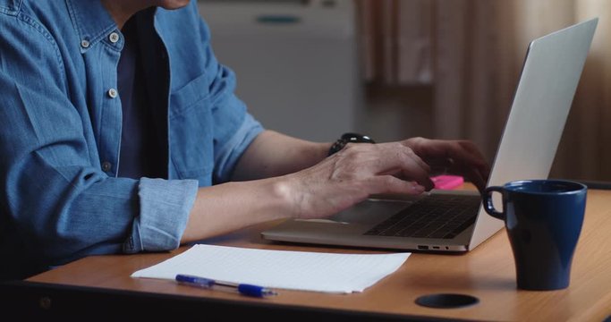 Man working from home with laptop computer with successful