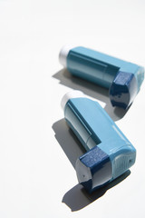 Many Asthma inhalers lying on white background