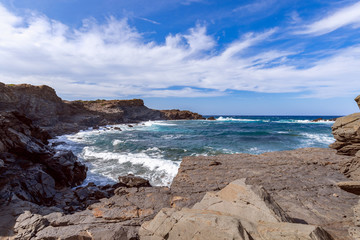 Fototapeta na wymiar Beautiful view of a rocky bay with waves on the sea on the island of Menorca, Balearic islands, Spain