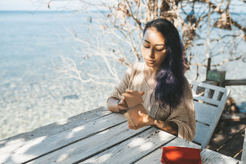 Woman is reading Tarot cards sitting at the table outdoors