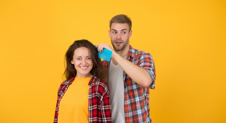 Combing and brushing hair. Man and woman taking care hair themselves. Hairdresser services. Creative mood. Change hairdo. Hair care at home. Helping with hairstyle. Couple having fun with big comb