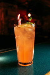 Alcoholic  summer Cocktail. Alcoholic beverage based on table with ice cubes and oranges.