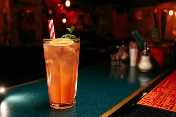 Alcoholic  summer Cocktail. Alcoholic beverage based on table with ice cubes and oranges.