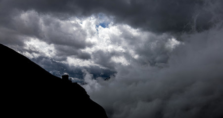 silhouetted mountains against a background of large clouds