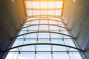 Glass curtain walls attach with grey brick wall. Architecture abstract background. Fasteners elements of transparent glass. The sun shines through glass buildings. Facades details.