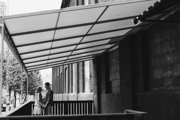 Romantic and happy caucasian couple in casual clothes walking together through the city streets. Love, relationships, romance, happiness concept. Man and woman holding hands and smiling.