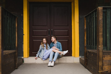 Romantic and happy caucasian couple in casual clothes walking together through the city streets. Love, relationships, romance, happiness concept. Man and woman holding hands and smiling.