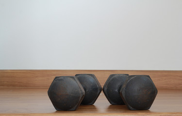 Old iron dumbbells or exercise weights outdoor on a wooden floor