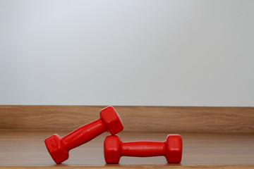 Red modern dumbbells on a wooden floor