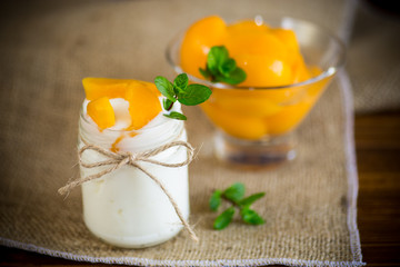 homemade sweet yogurt with slices of pickled peaches in a glass jar