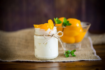 Obraz na płótnie Canvas homemade sweet yogurt with slices of pickled peaches in a glass jar