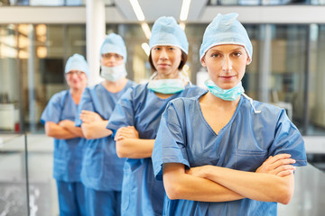 Surgeon with crossed arms in front of her team