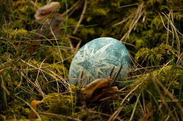 Easter painted blue egg with star on moss