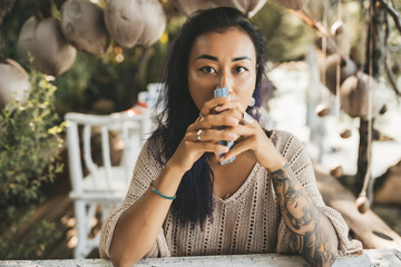 Woman is reading Tarot cards sitting at the table outdoors