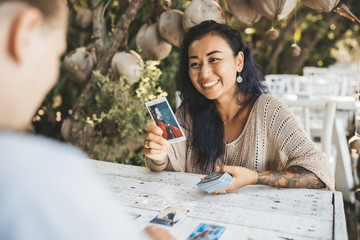 Woman is reading Tarot cards with a customer outdoors