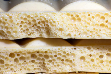 Background, texture of porous white chocolate close-up.