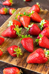 Ripe strawberries on a wooden chopping board.