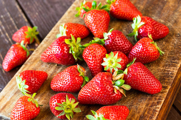 Ripe strawberries on a wooden background, top view.