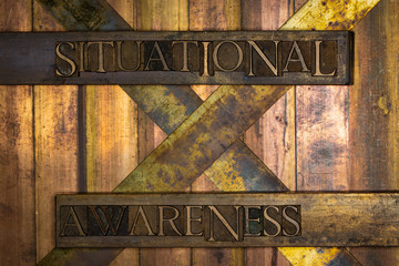 Photo of real authentic typeset letters Situational Awareness text on vintage textured grunge copper and gold background