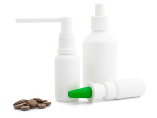Different sprays and vials of white color and a handful of tablets on a white background, mock up. Layout for branding, advertising, presentation, and design. Medical sprays and antiseptics
