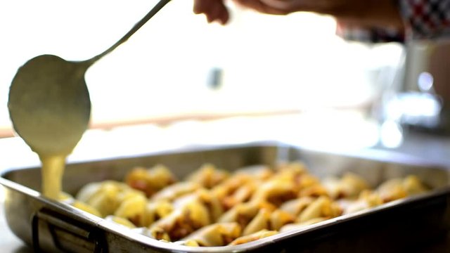 Preparation of homemade lumaconi filled in with tomato sauce and minced meat. Adding some cheese and b&eacute;chamel sauce. Italian pasta recipe