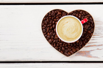 Top view coffee with creamy foam. Coffee heart symbol of love on white wood.