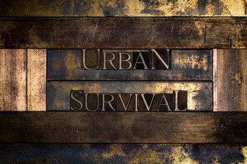 Photo of real authentic typeset letters Urban Survival text on vintage textured grunge copper and gold background