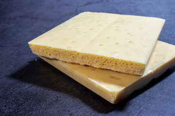 Broken bar of white chocolate on a black background. A delicious bar of milk chocolate. Selective focus