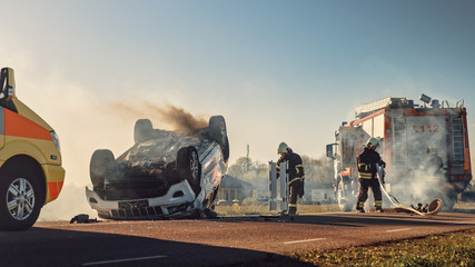 Fototapeta na wymiar On the Car Crash Traffic Accident Scene: Paramedics and Firefighters Rescue Injured Victims Trapped in the Vehicle. Medics Use Stretchers, Perform First Aid. Firemen Grab Equipment.