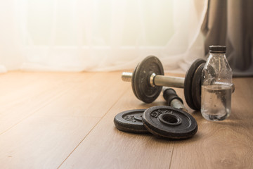 dumbbells for sports at home on the wooden floor for the period of isolation. disk for bodybuilding.
