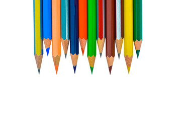 Line of different colored wood pencil crayons placed before a white background
