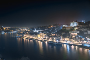 Panoramic landscape view on the old town with Douro river in Porto city at night in Portugal