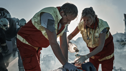 On the Car Crash Traffic Accident Scene: Paramedics Saving Life of a Female Victim who is Lying on...