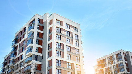 Fototapeta premium Modern apartment buildings on a sunny day with a blue sky. Facade of a modern apartment building. Glass surface with sunlight.