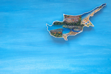 Magnet with the inscription Cyprus C in the form of an island shape on a blue, sea background