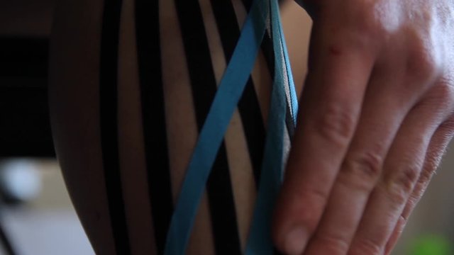 Doctor glues a tepee to an athlete at the gym
